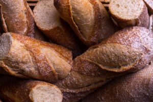Rustic fresh baguettes in a basket, showcasing crusty textures and artisanal baking.
