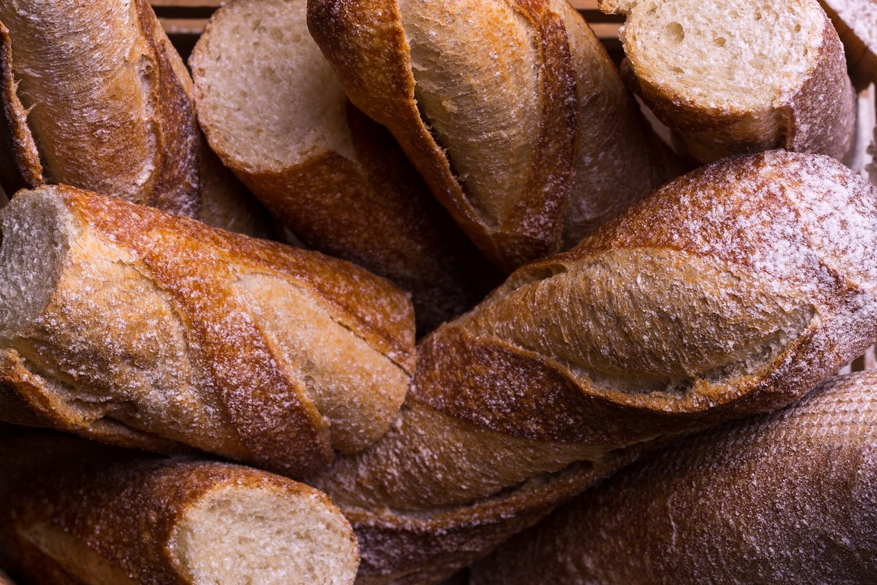 Rustic fresh baguettes in a basket, showcasing crusty textures and artisanal baking.