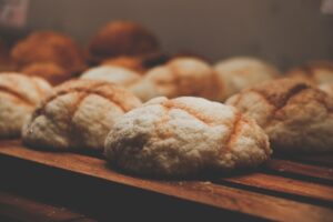 Freshly baked Taiwanese breads on a wooden tray in warm lighting.