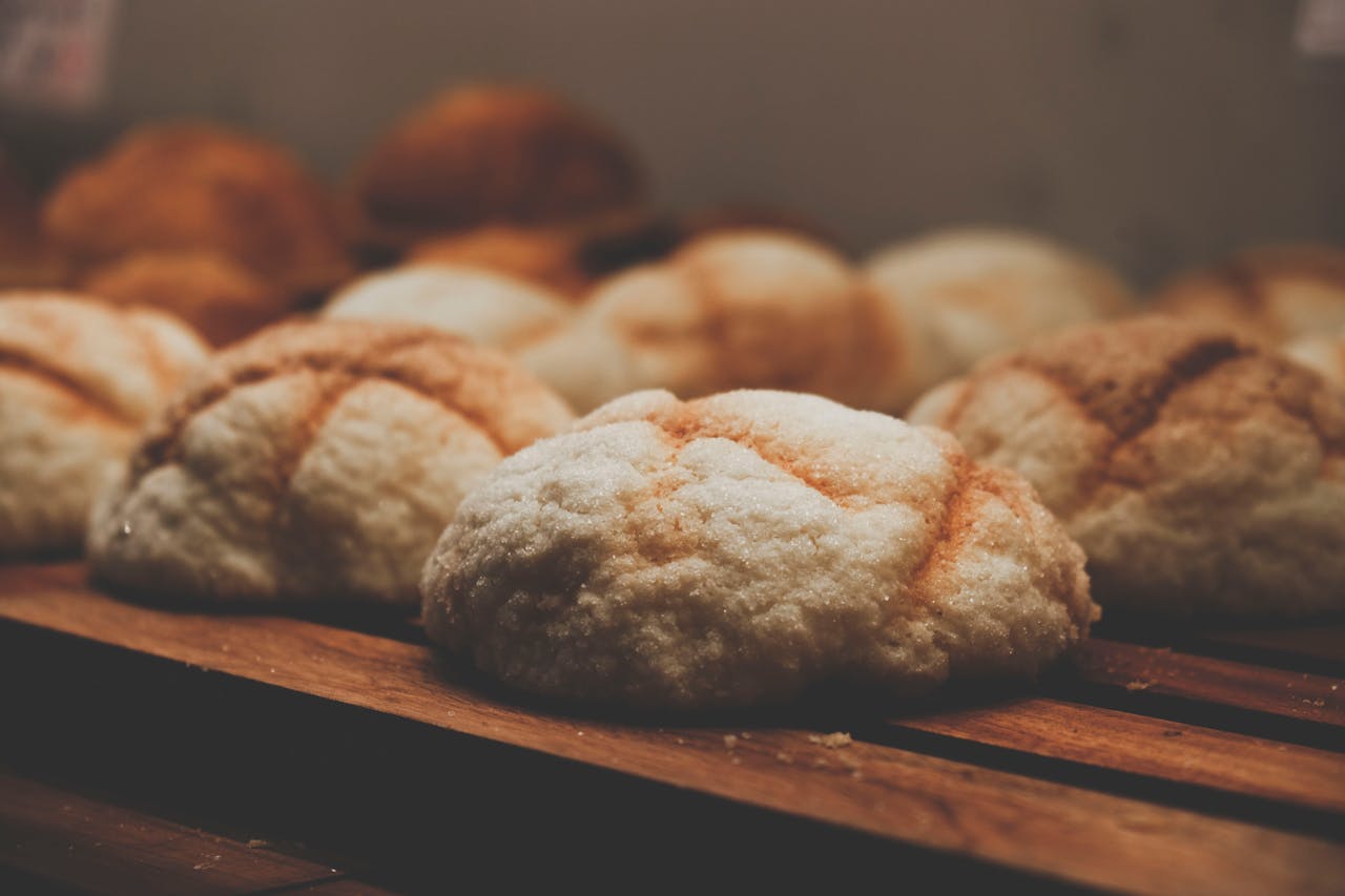 Freshly baked Taiwanese breads on a wooden tray in warm lighting.