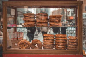 Turkish street vendor stall displaying fresh simit bagels on a bustling city street.